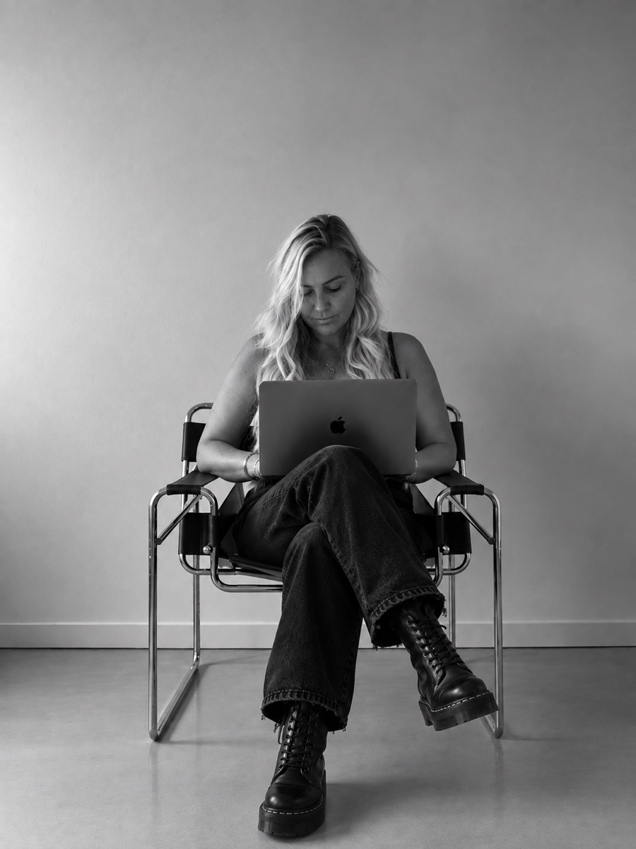 Charlotte Pearce seated with a laptop on her knee